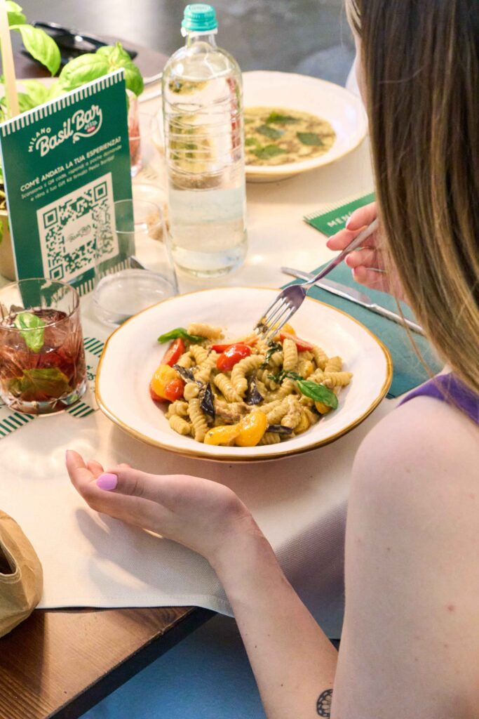 Basil Bar 3 Donna che mangia un piatto di pasta al pesto e verdure al tavolo del Basil Bar