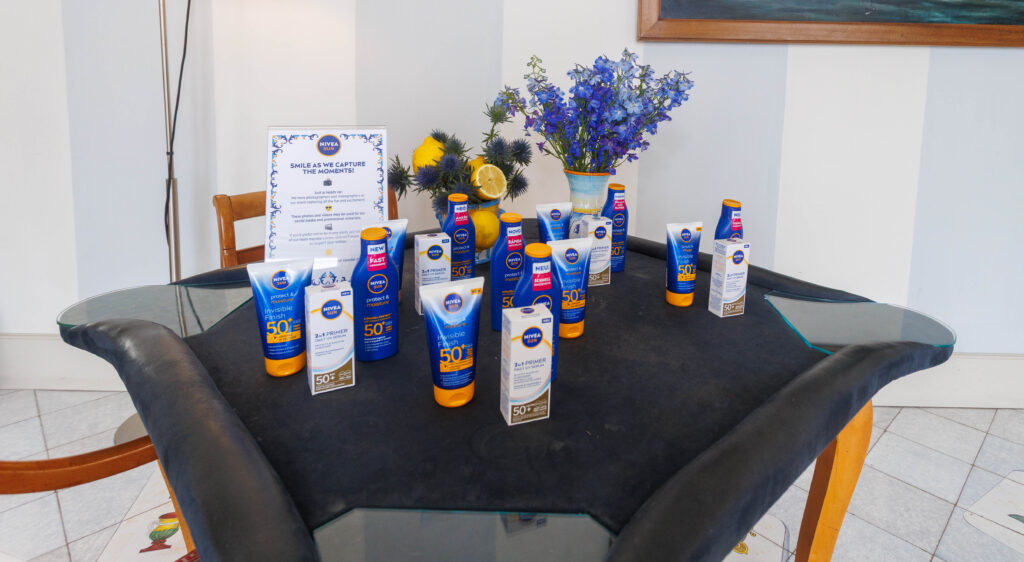 Nivea Sun Ischia 12 Tavolo con esposizione di fiori e prodotti solari Nivea Sun